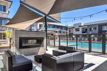 A patio with a fireplace and seating area.